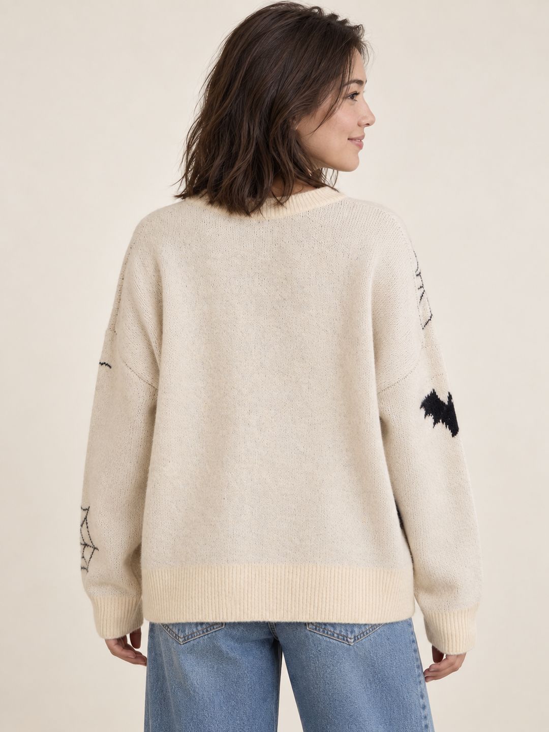Cream pumpkin and bat Halloween sweater, back view on model