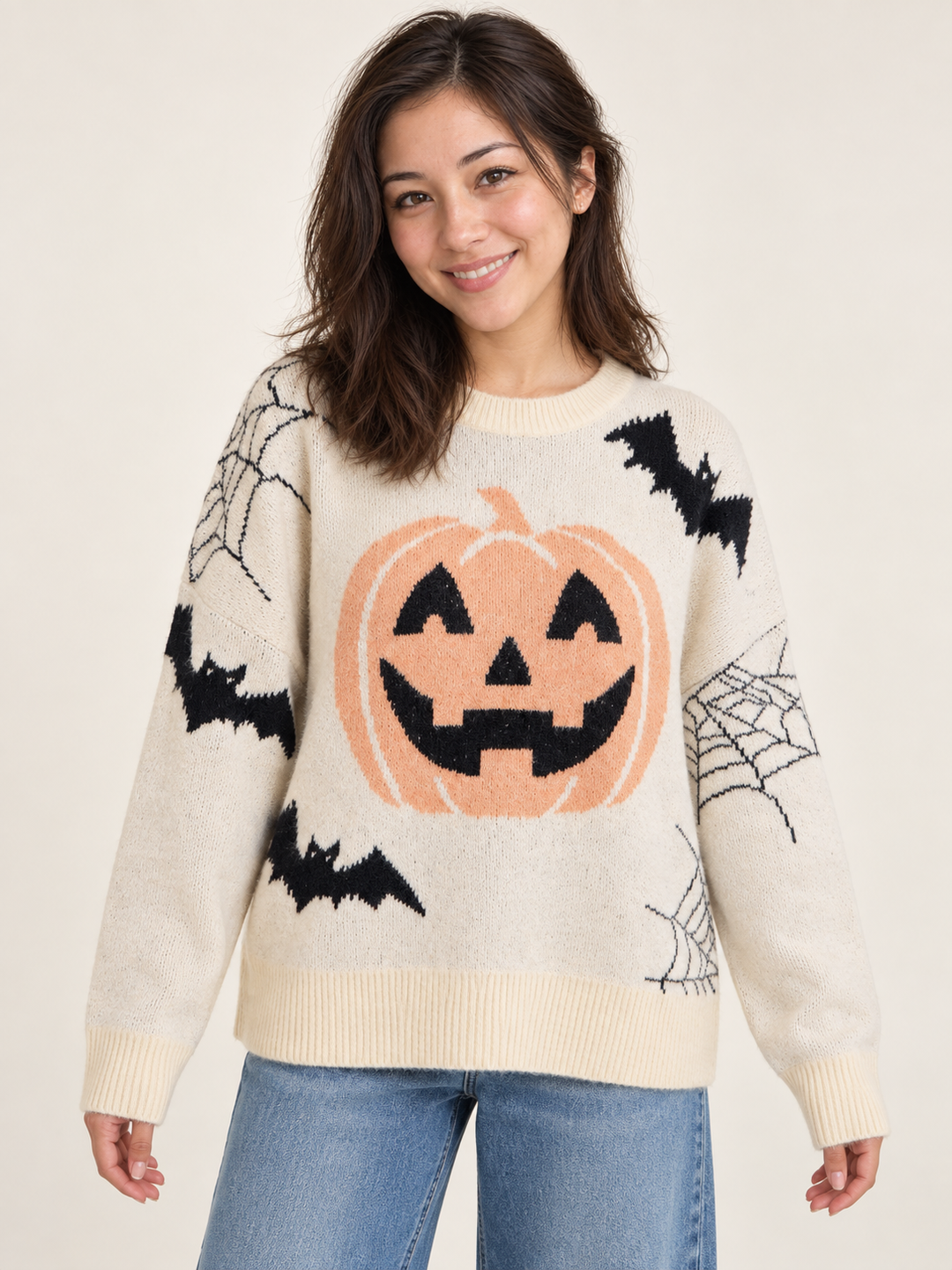 Cream pumpkin and bat Halloween sweater, front view on model