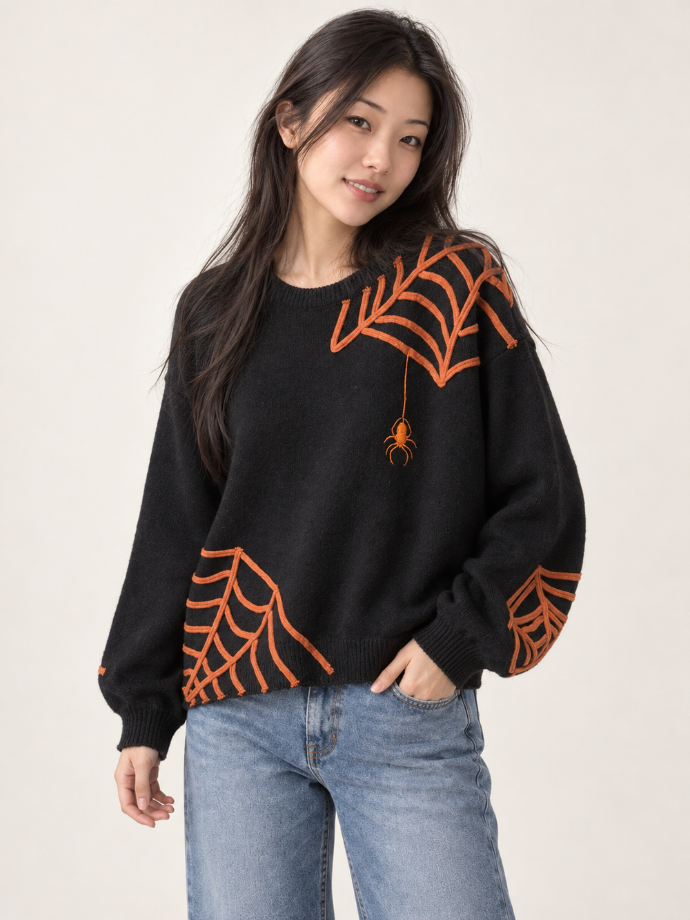Model wearing Halloween spider applique sweater, angled view