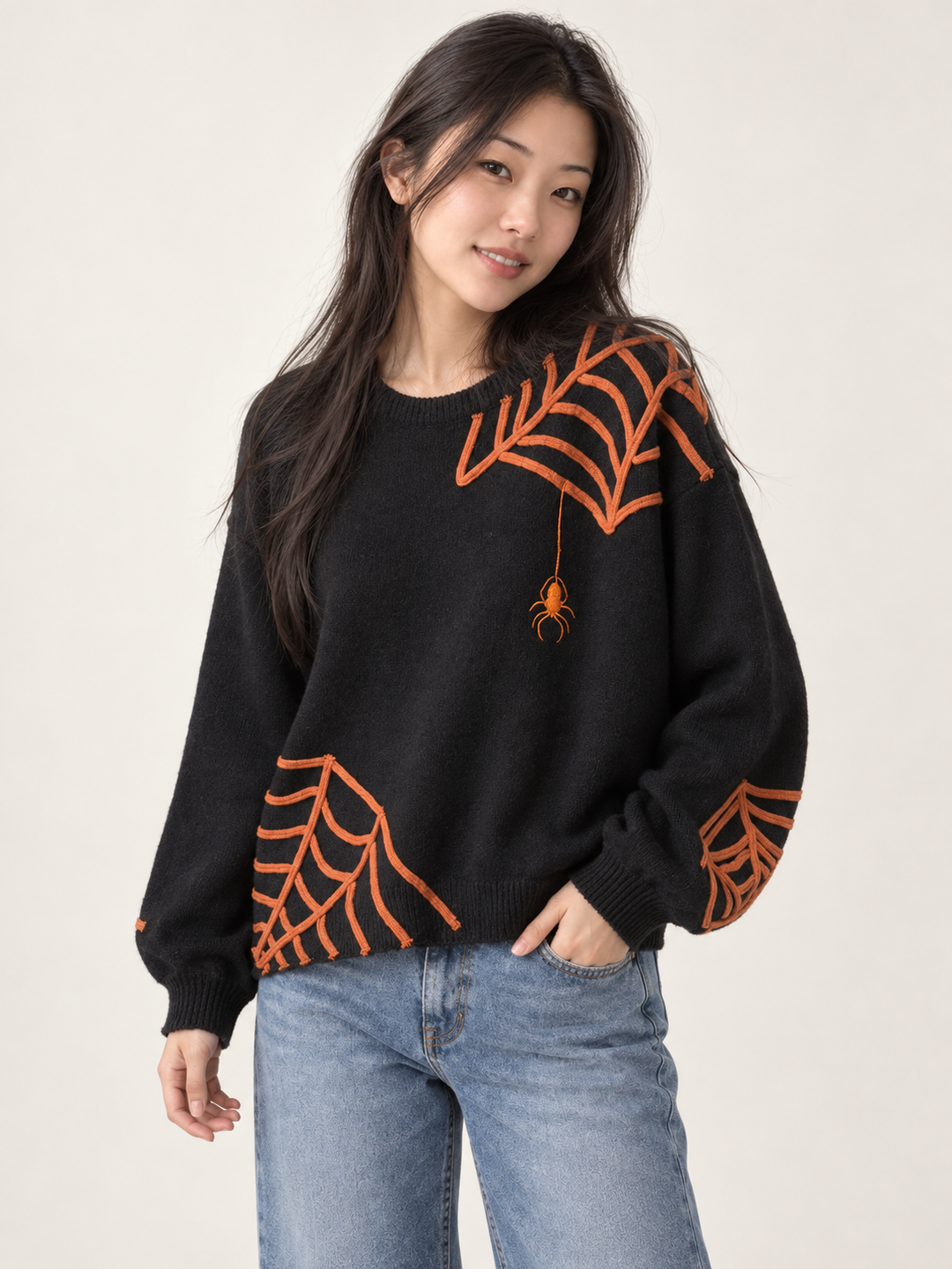 Model wearing Halloween spider applique sweater, angled view