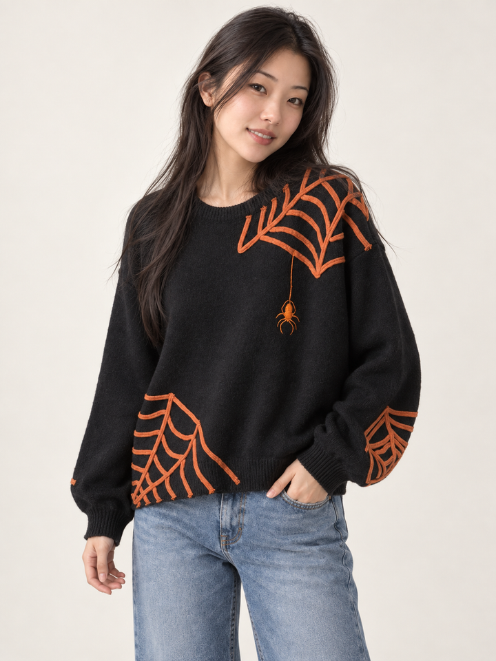 Model wearing Halloween spider applique sweater, angled view