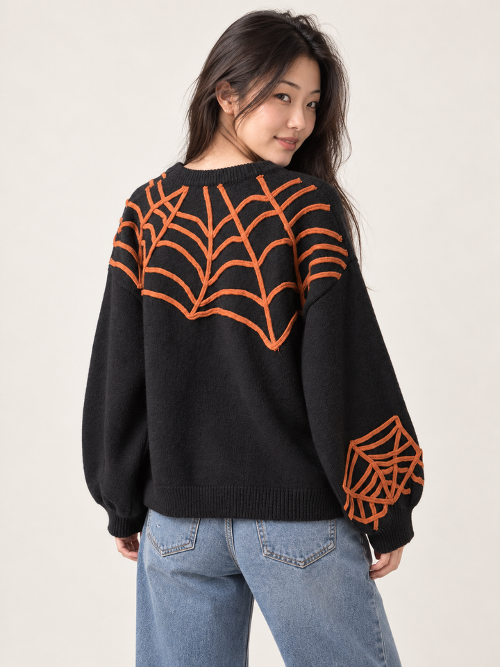 Model wearing Halloween spider applique sweater, back view