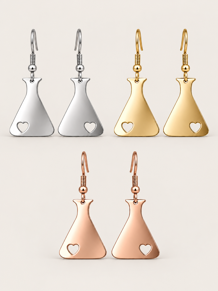 Heart Flask Drop Earrings in Silver, Gold and Rose Gold on a warm neutral background