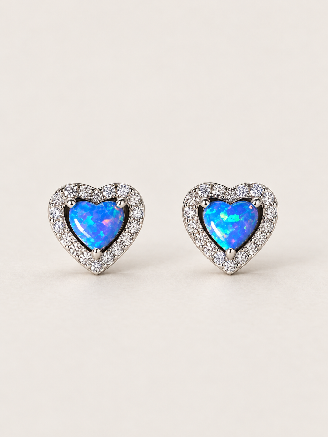 Blue Heart Halo Stud Earrings shown on a warm neutral background
