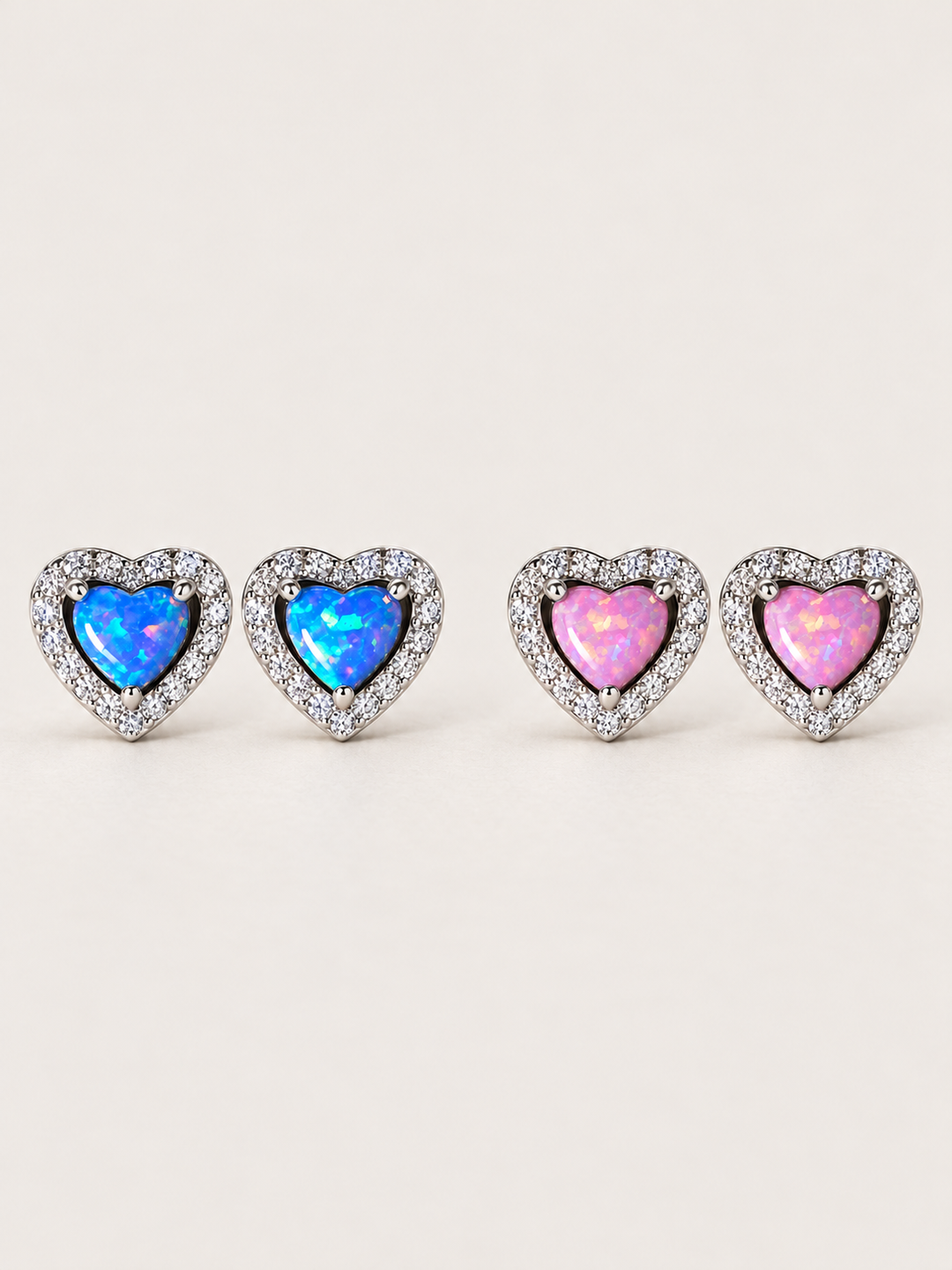 Heart Halo Stud Earrings in Blue and Pink sterling silver shown on a warm neutral background