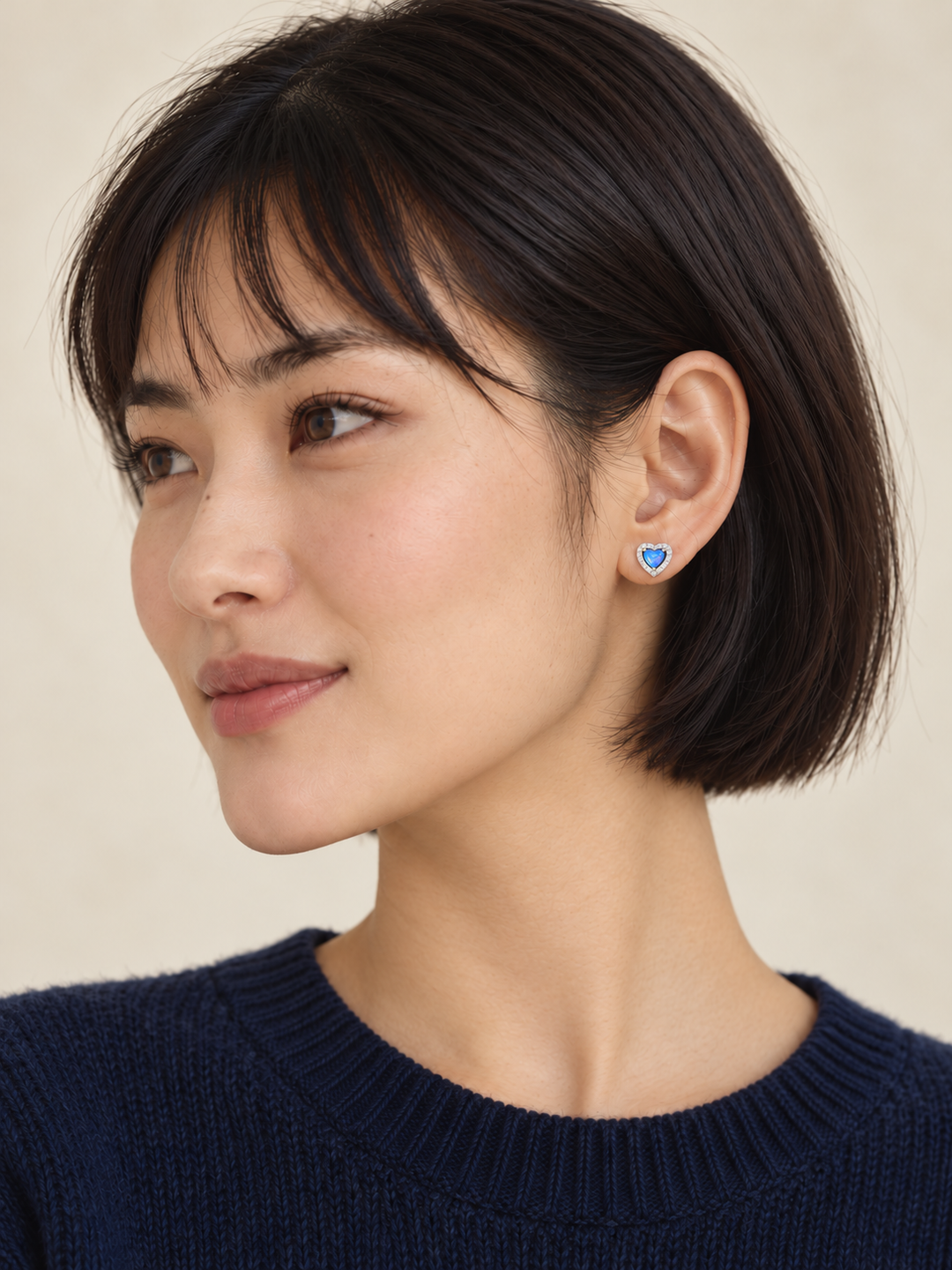 Blue Heart Halo Stud Earrings worn on a model with a navy sweater
