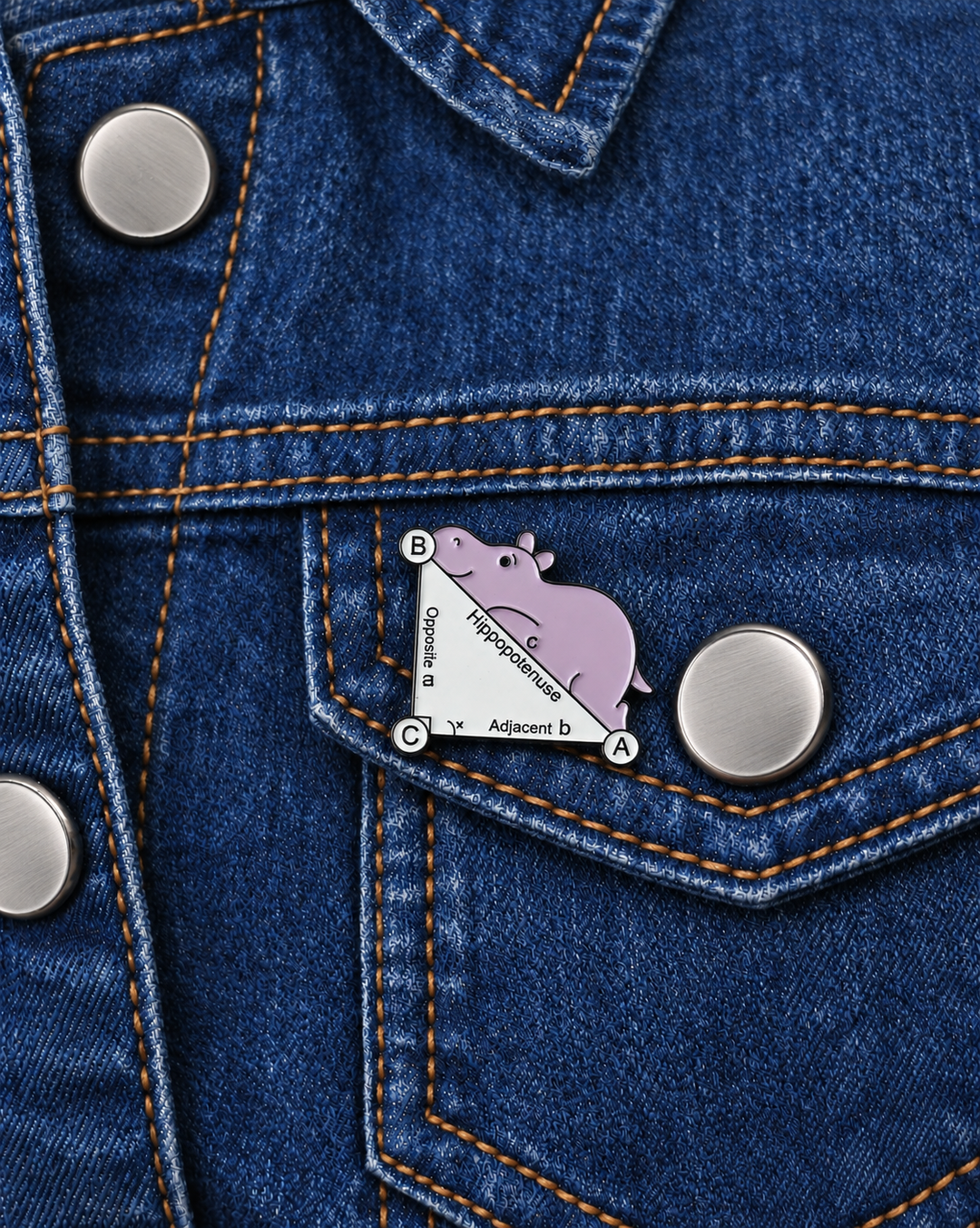Hippo on the Hypotenuse Pin displayed on dark indigo denim beside a metal button