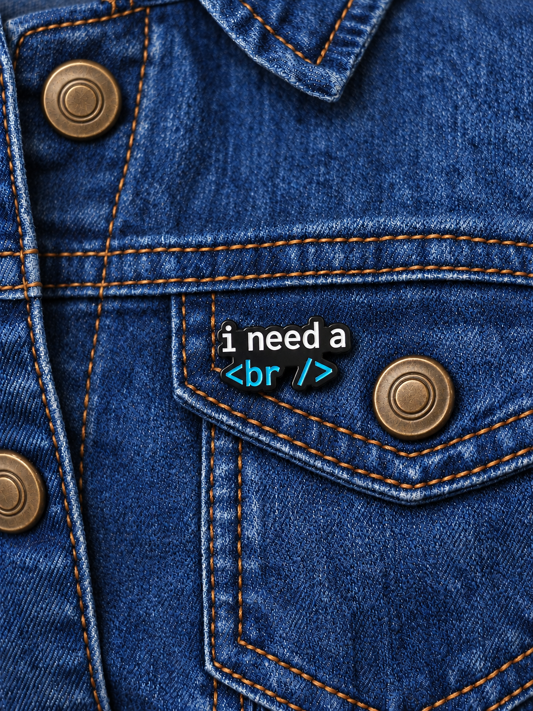 I Need a Break Code Pin displayed on a dark indigo denim jacket beside a metal button