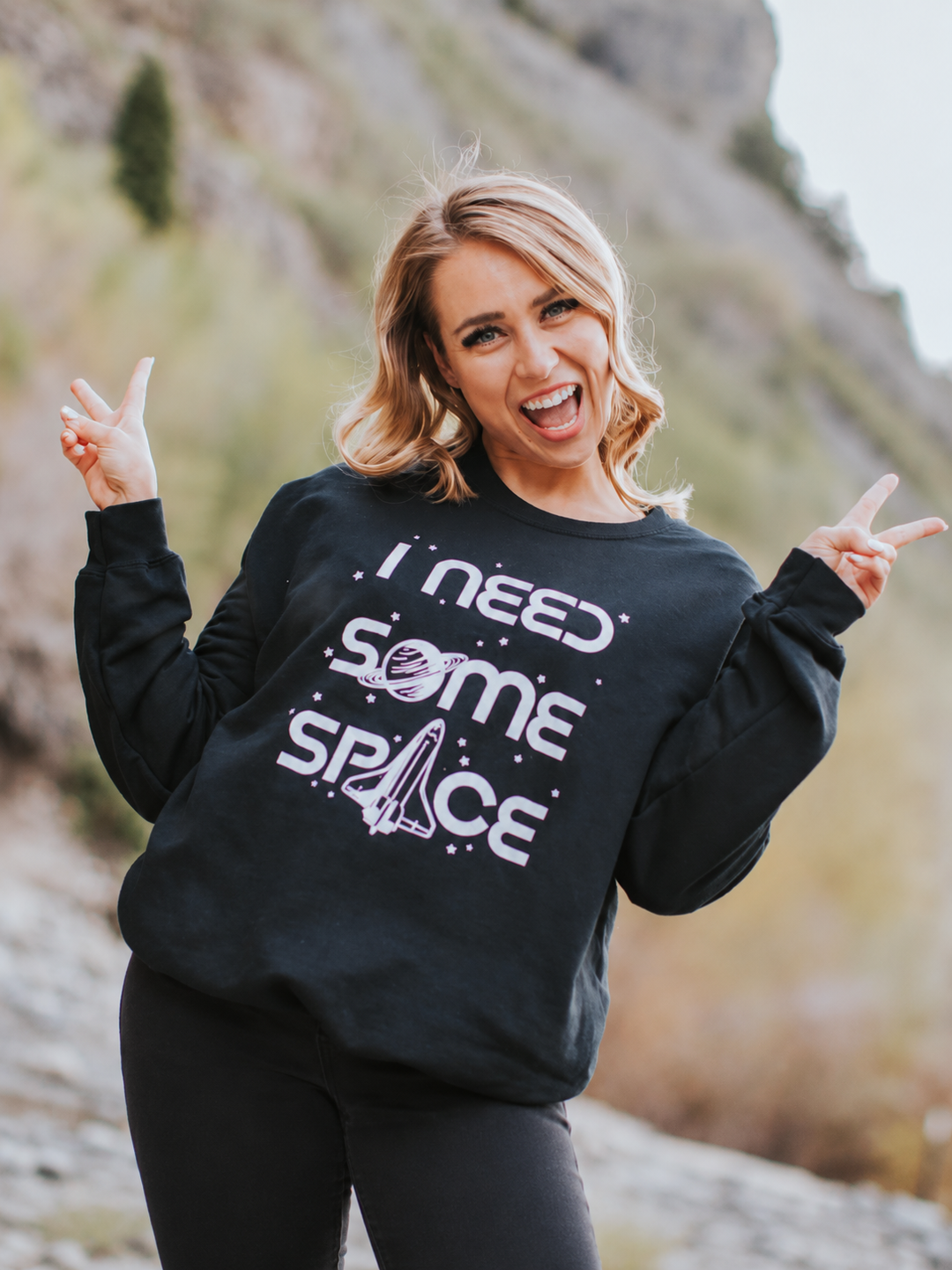 Model posing in black I Need Some Space sweatshirt