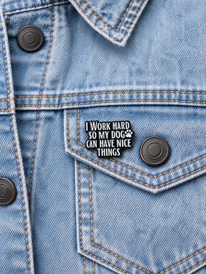 I Work Hard So My Dog Can Have Nice Things Pin displayed on a light-wash denim jacket beside a metal button
