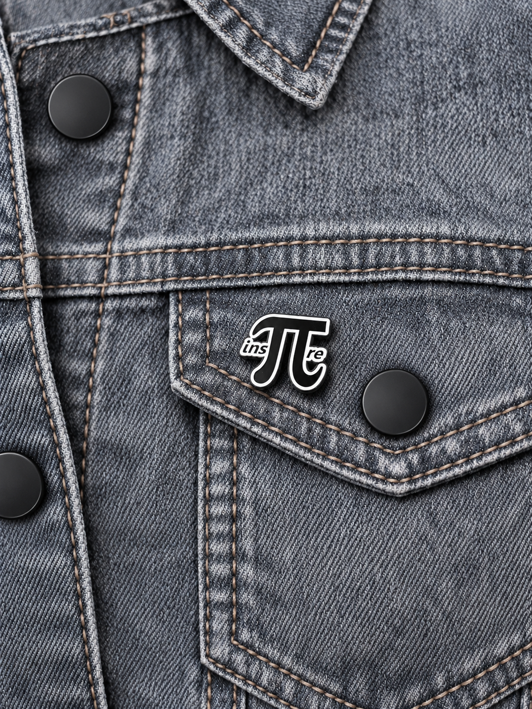 Inspire Pi Math Pin displayed on gray stonewash denim beside a black button