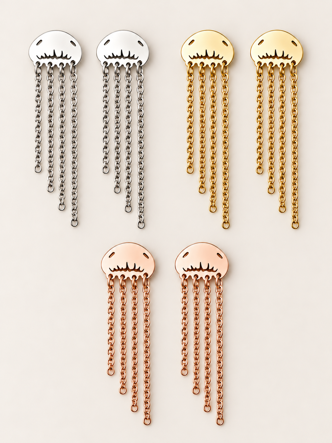 Jellyfish Chain Drop Earrings in Silver, Gold and Rose Gold on a warm neutral background