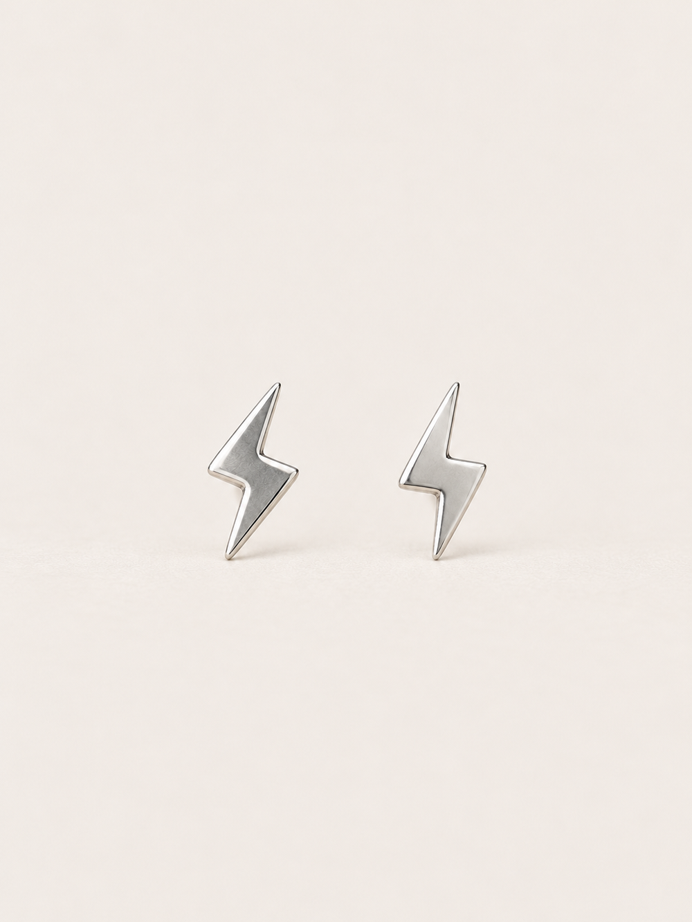Silver Lightning Bolt Earrings on a warm neutral background