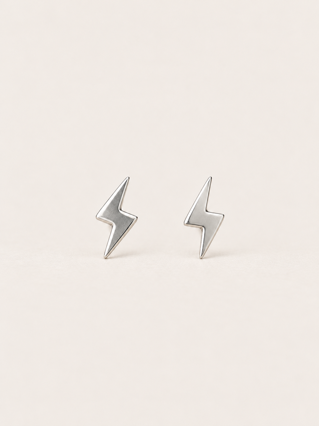 Silver Lightning Bolt Earrings on a warm neutral background