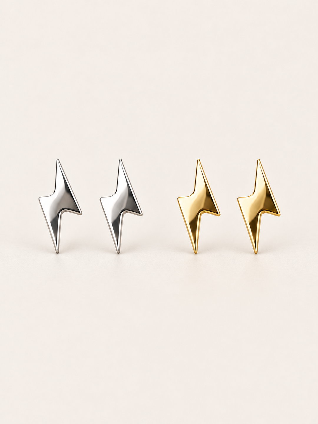 Silver and gold Lightning Bolt Stud Earrings shown on a warm neutral background