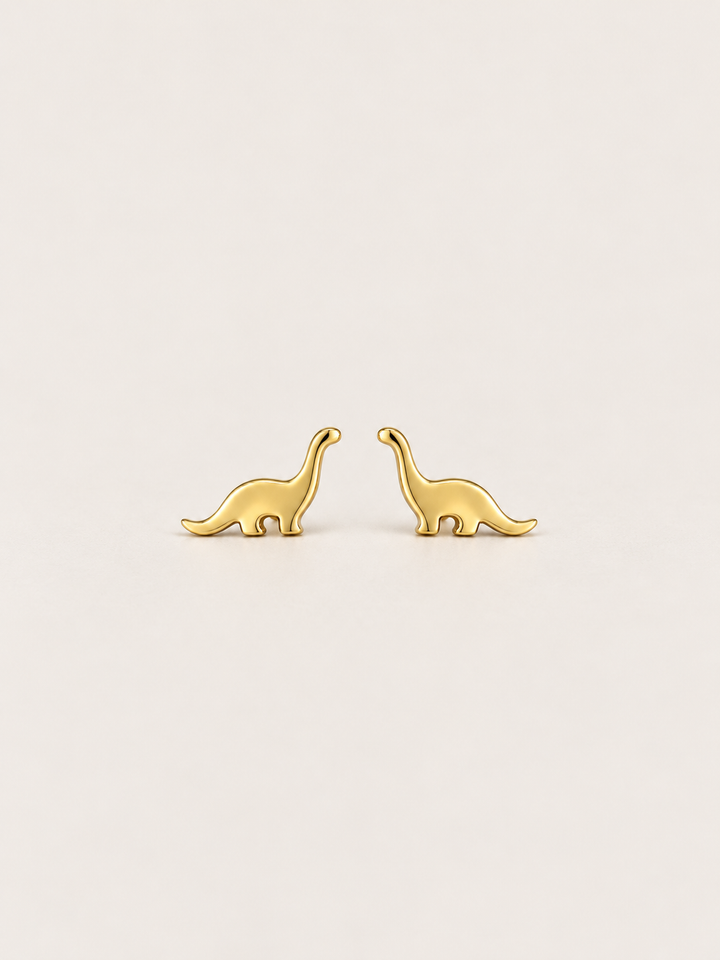 Long Neck Dinosaur Stud Earrings in gold on a warm neutral background