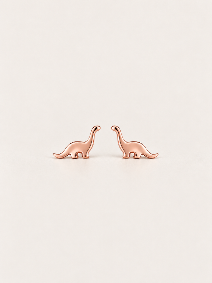 Long Neck Dinosaur Stud Earrings in rose gold on a warm neutral background