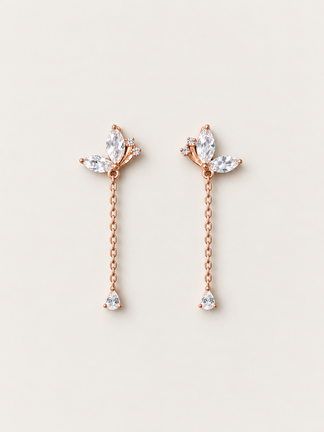Marquise Crystal Chain Drop Earrings in rose gold shown on a warm neutral background