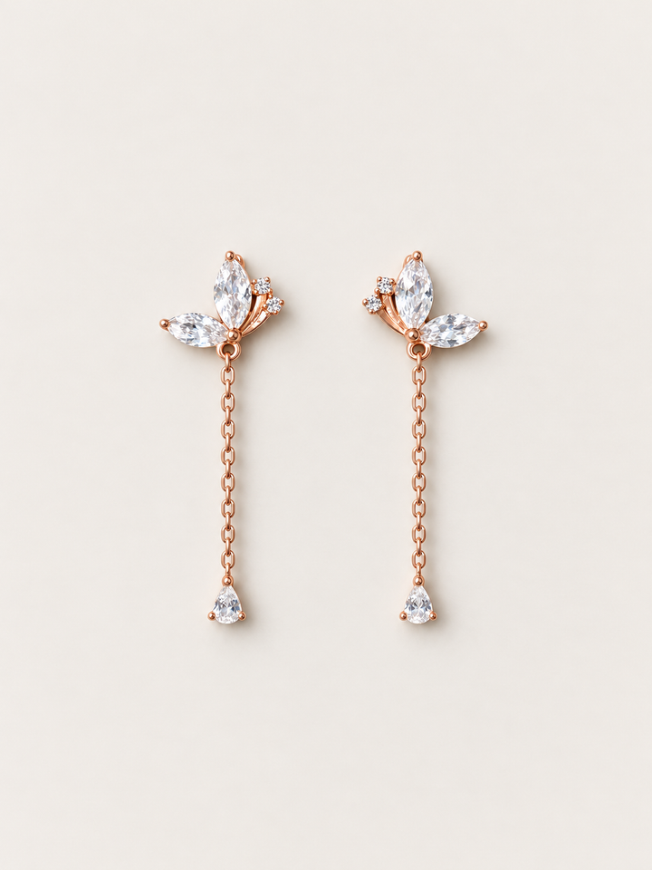 Marquise Crystal Chain Drop Earrings in rose gold shown on a warm neutral background