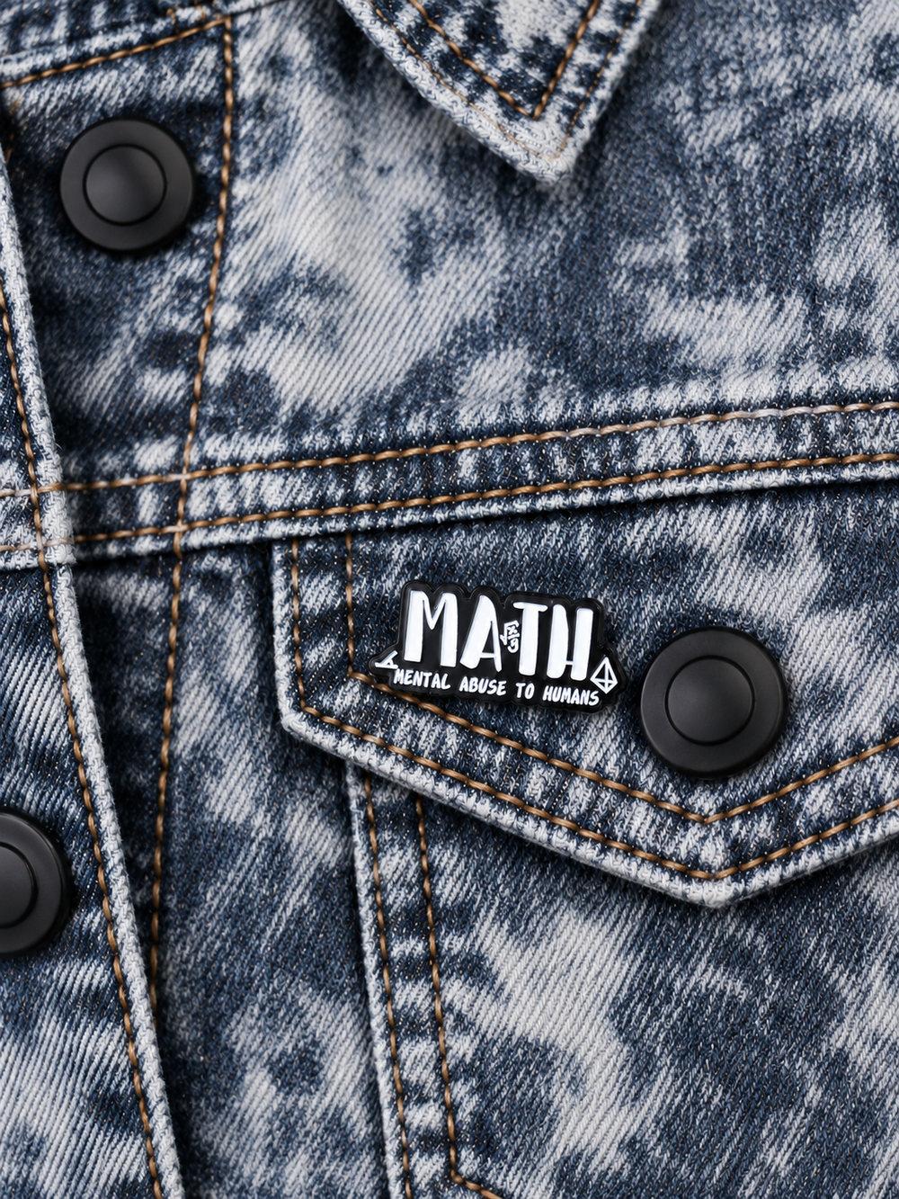 Mental Abuse to Humans Math Pin displayed on an acid-wash denim jacket beside a metal button