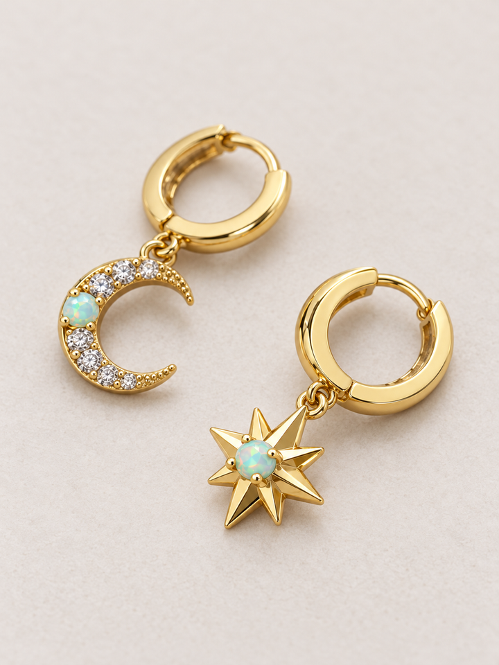 Moon and Star Huggie Earrings shown angled on a warm neutral background