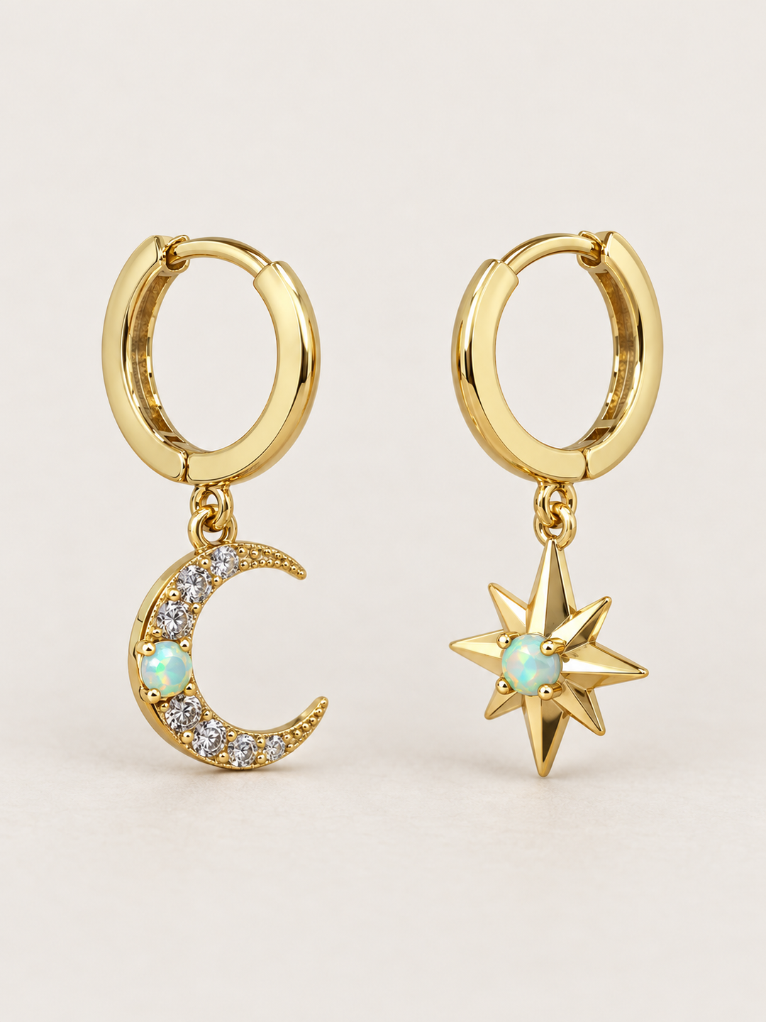 Moon and Star Huggie Earrings shown on a warm neutral background