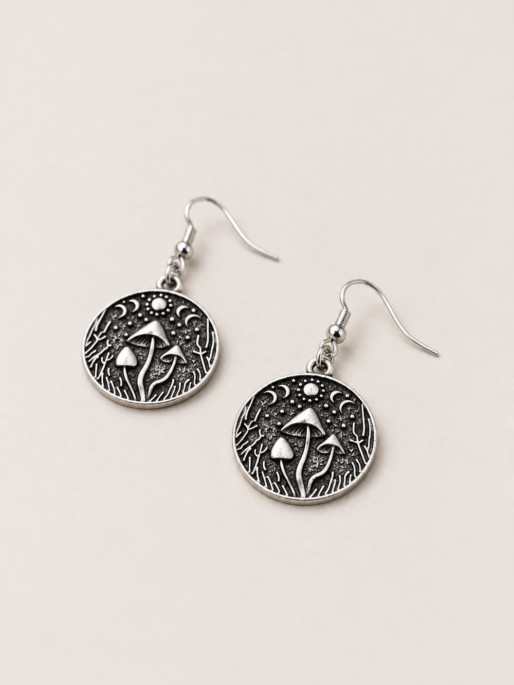 Mushroom Forest Drop Earrings lying flat at an angle on a warm neutral background