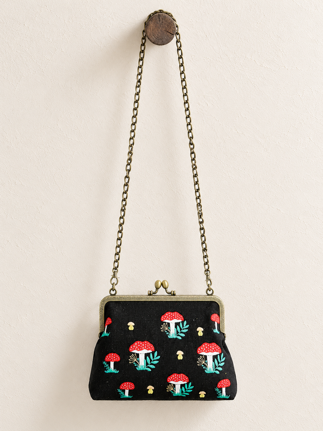 Mushroom Kisslock Bag hanging from long chain strap