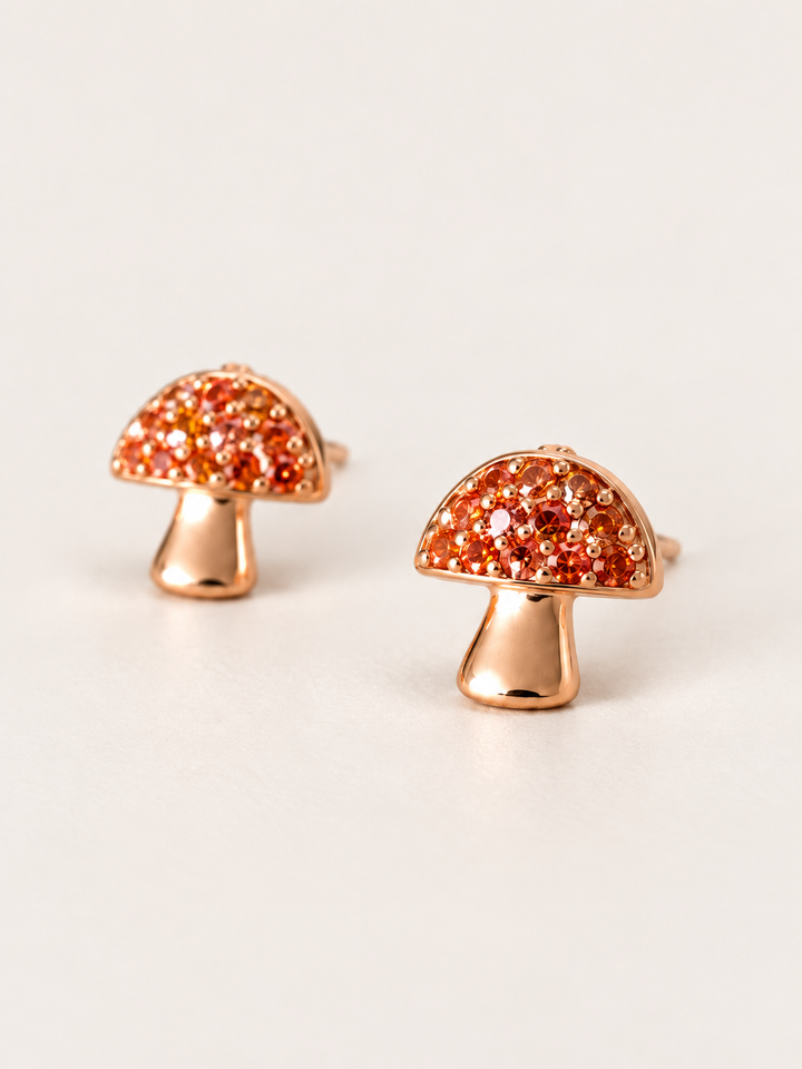 Mushroom Stud Earrings shown angled on a warm neutral background