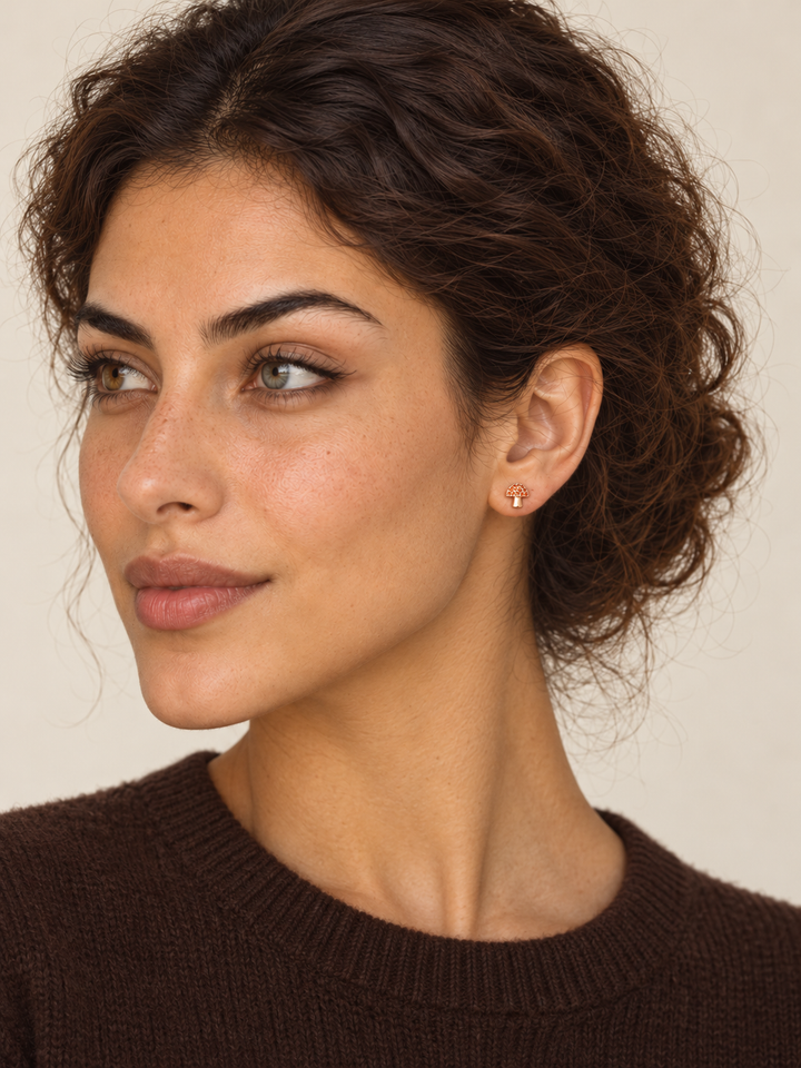 Rose gold Mushroom Stud Earrings worn on a model's viewer-right ear