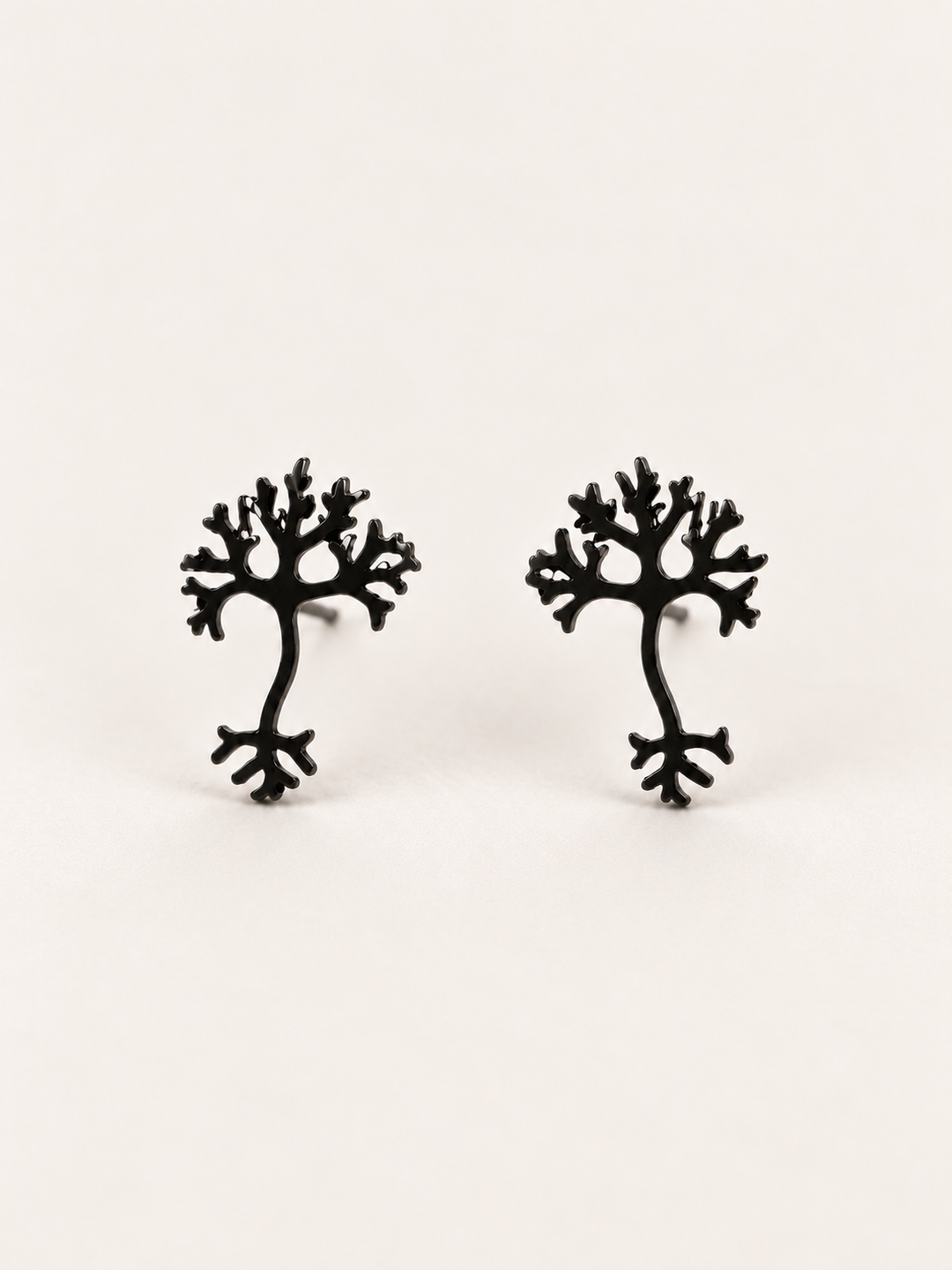 Black stainless steel Neuron Stud Earrings shown angled on a warm neutral background