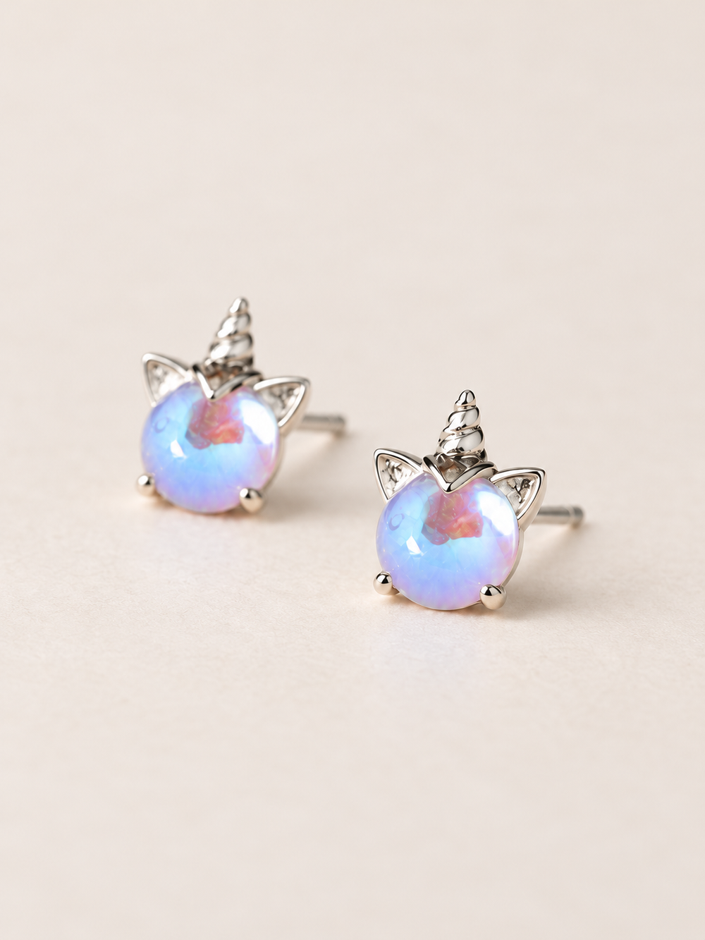 Opal Unicorn Stud Earrings shown angled on a warm neutral background