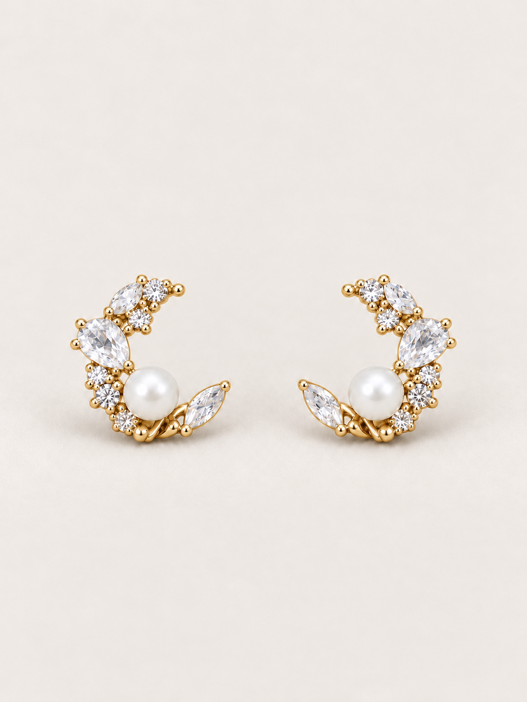 Gold Pearl Crystal Crescent Earrings shown on a warm neutral background