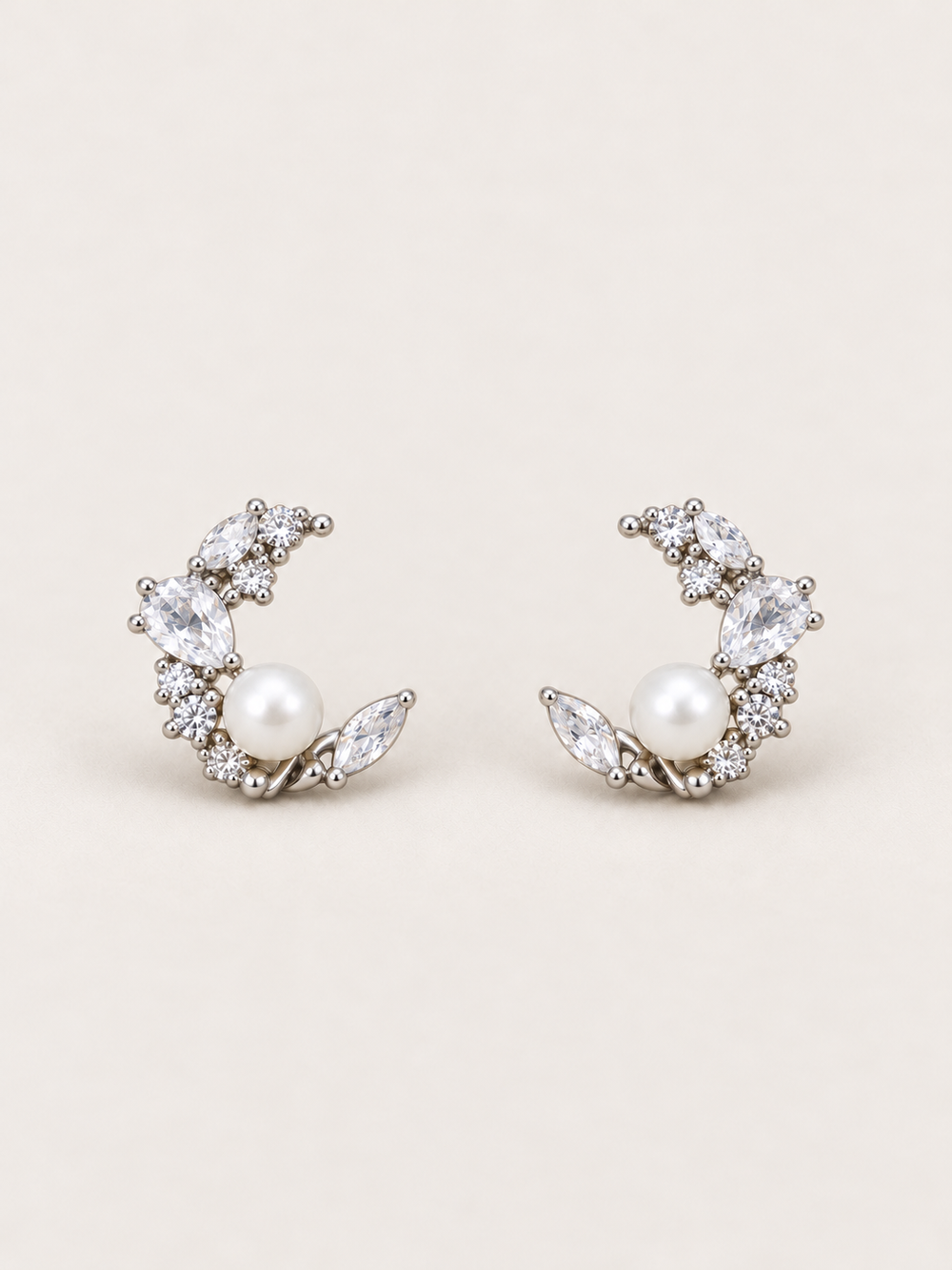 Silver Pearl Crystal Crescent Earrings shown on a warm neutral background
