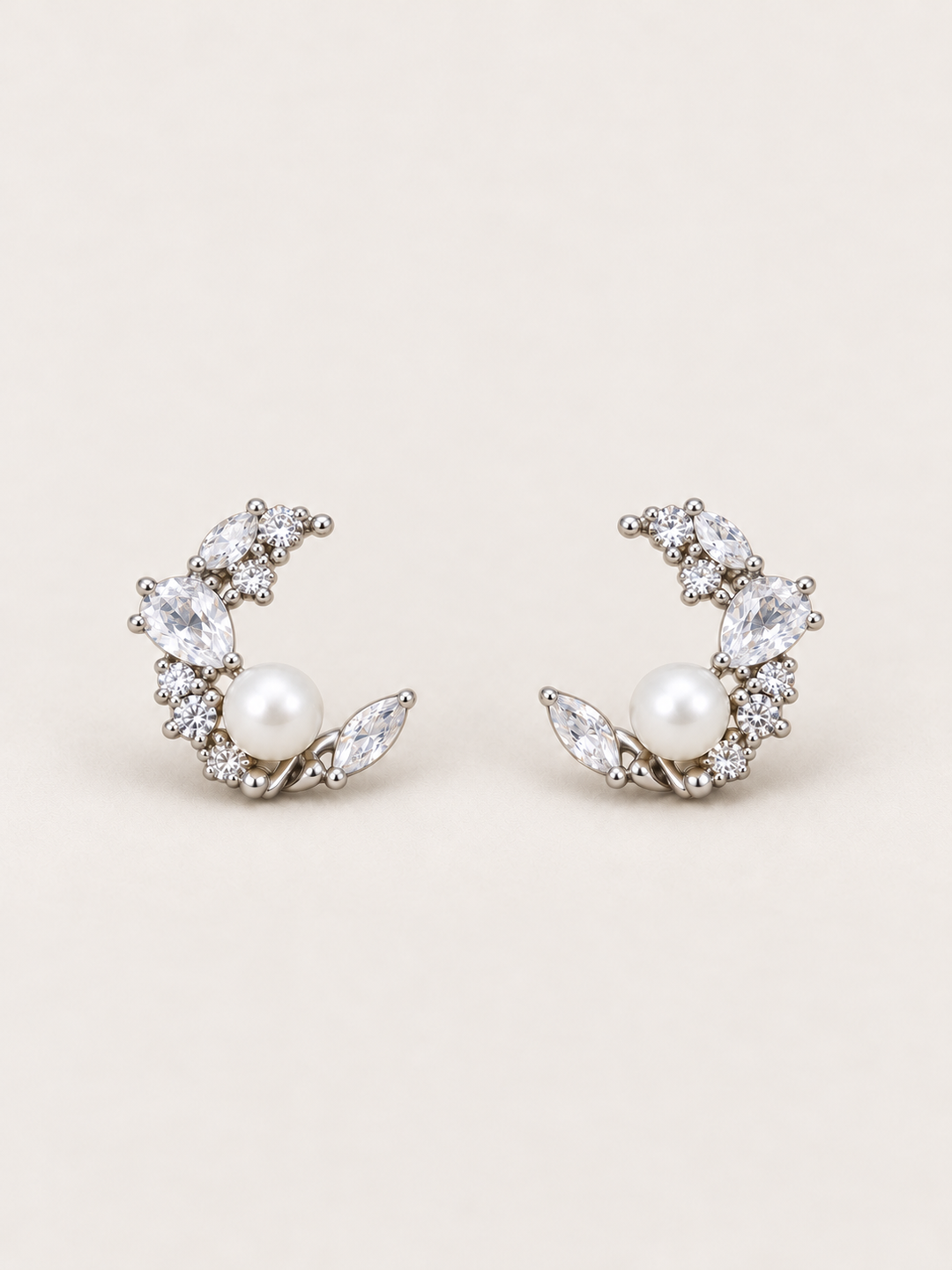 Silver Pearl Crystal Crescent Earrings shown on a warm neutral background