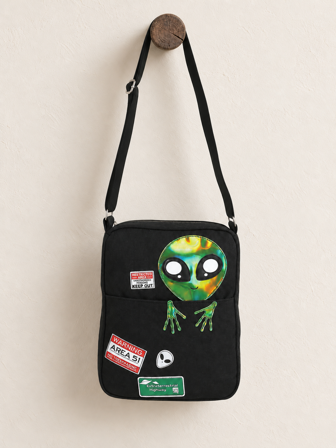 Peeking Alien Canvas Bag hanging from a wooden post
