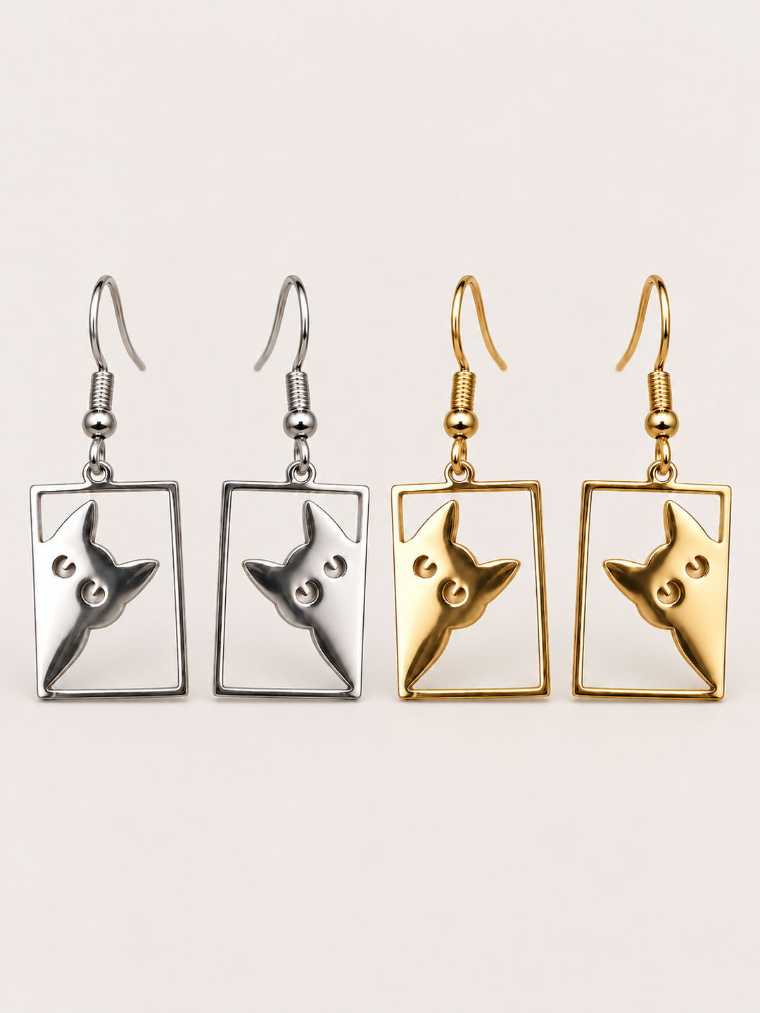 Peeking Cat Rectangle Drop Earrings in silver and gold on a warm neutral background