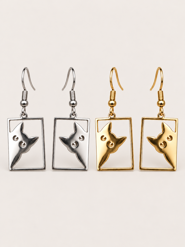 Peeking Cat Rectangle Drop Earrings in silver and gold on a warm neutral background