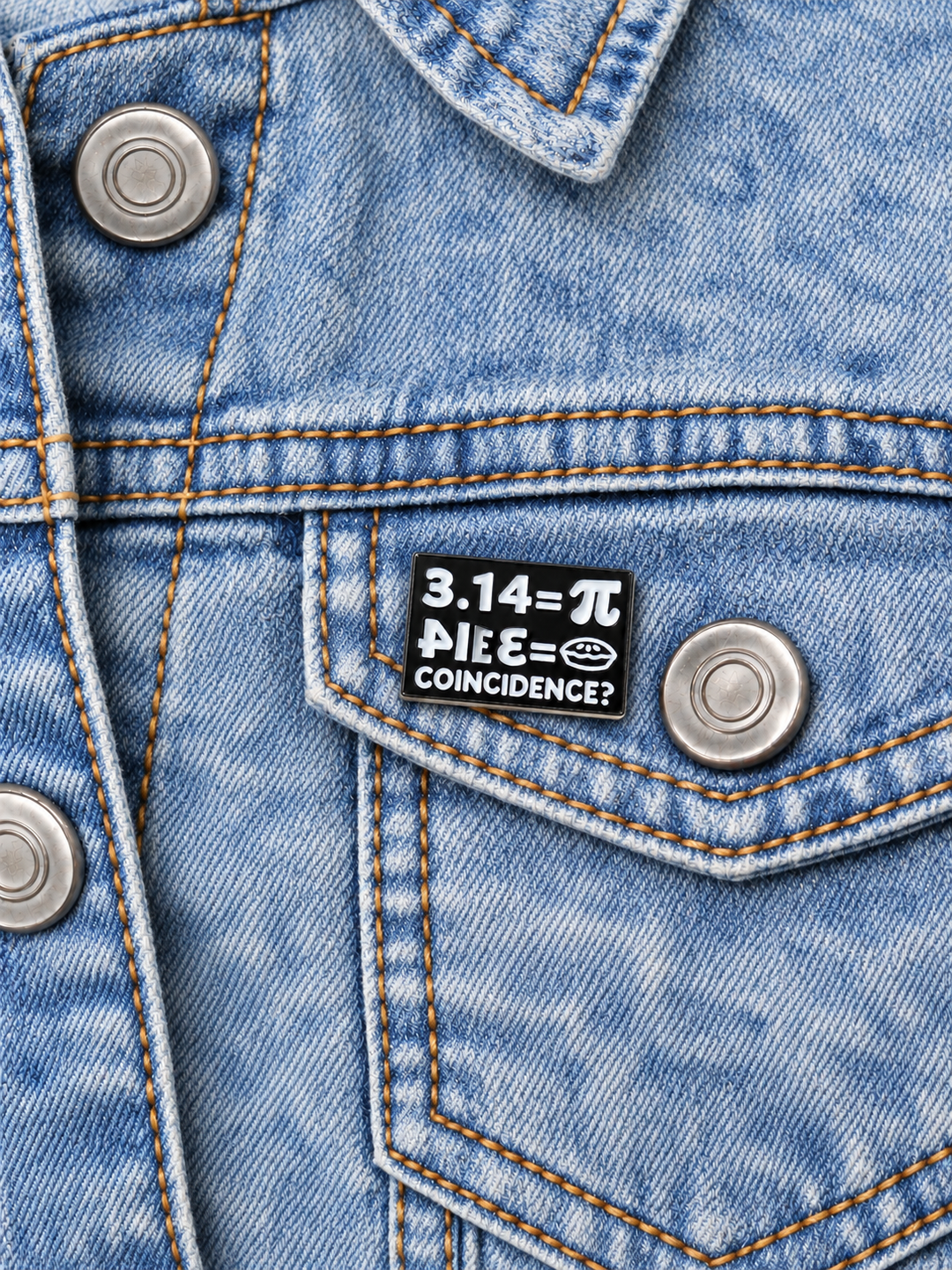 Pi Pie Coincidence Pin displayed on an acid-wash denim jacket beside a metal button