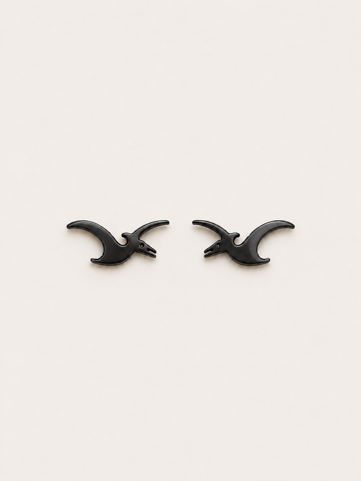 Pterodactyl Stud Earrings in Black on a warm neutral background