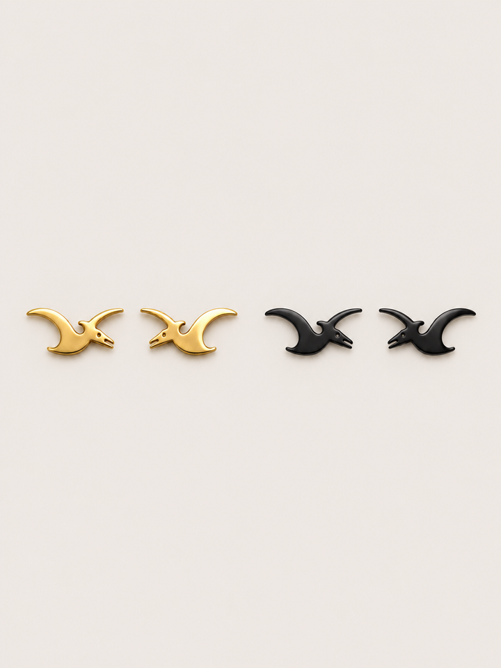 Pterodactyl Stud Earrings in Gold and Black on a warm neutral background