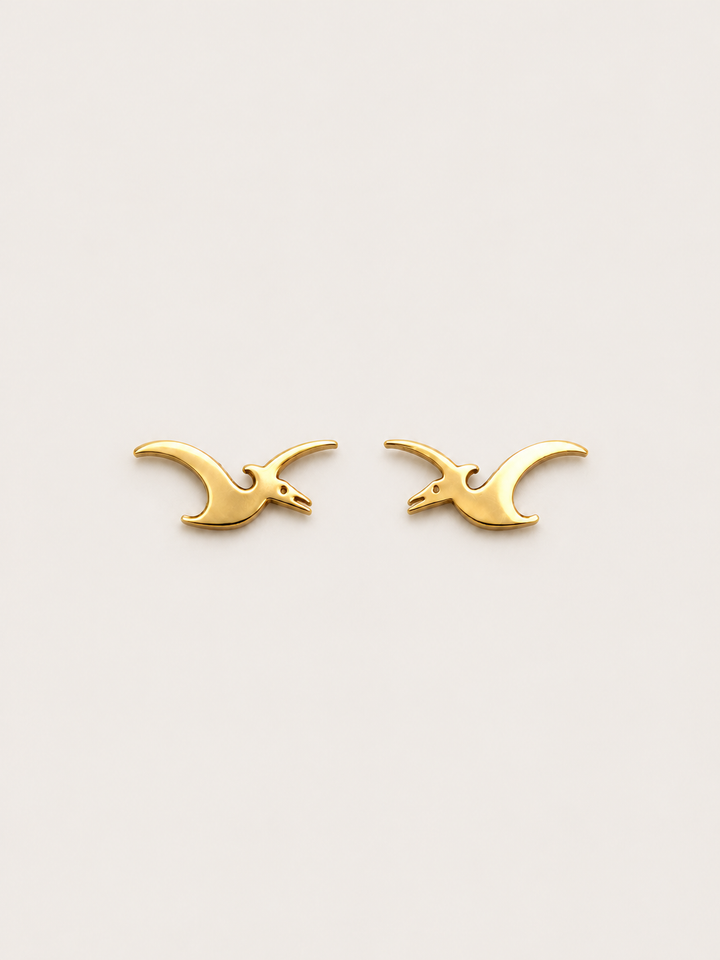 Pterodactyl Stud Earrings in Gold on a warm neutral background