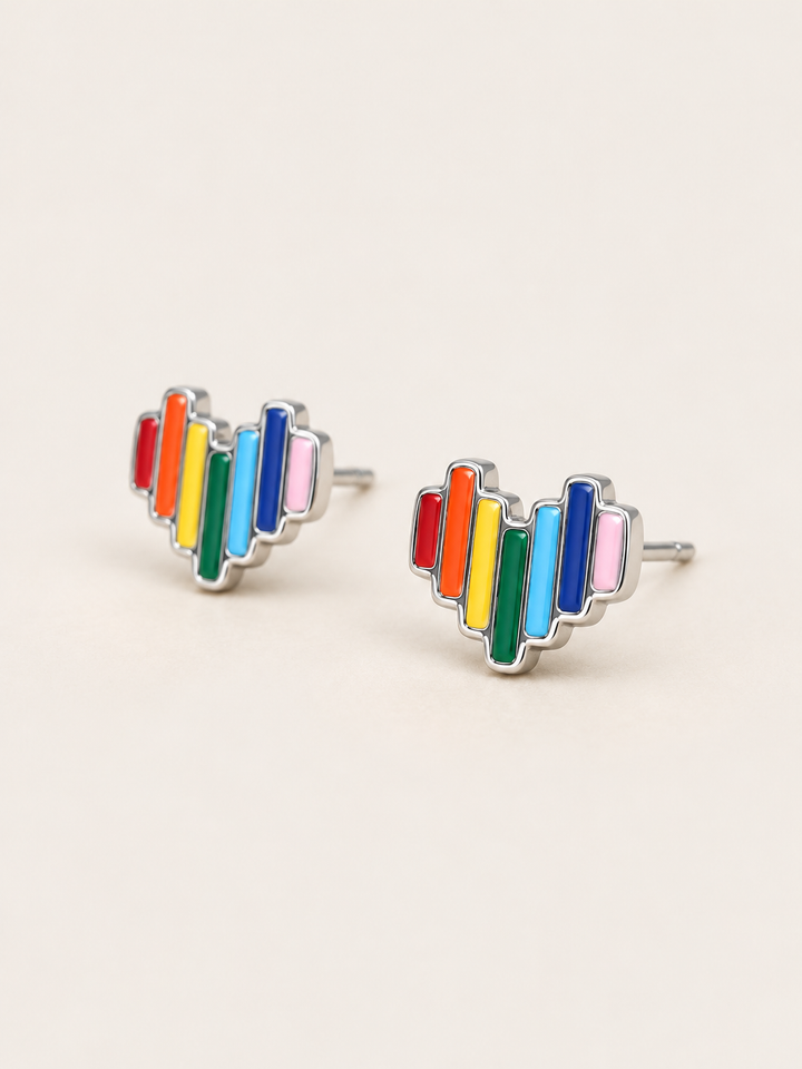 Rainbow Heart Stud Earrings shown angled on a warm neutral background
