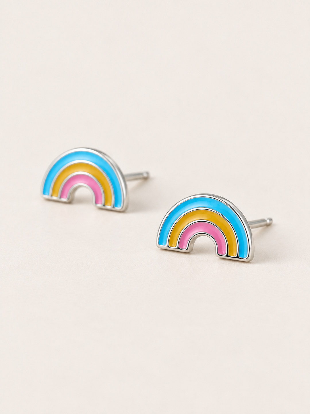 Enamel Rainbow Stud Earrings shown angled on a warm neutral background