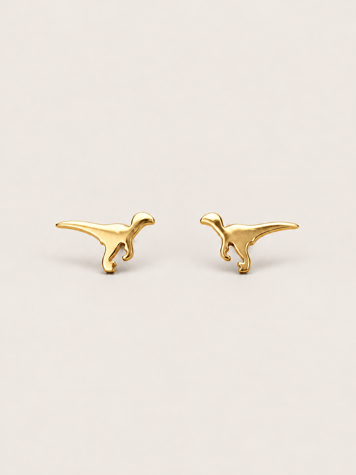 Gold Raptor Dinosaur Stud Earrings shown on a warm neutral background