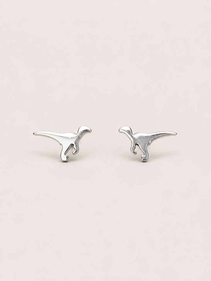 Silver Raptor Dinosaur Stud Earrings shown on a warm neutral background