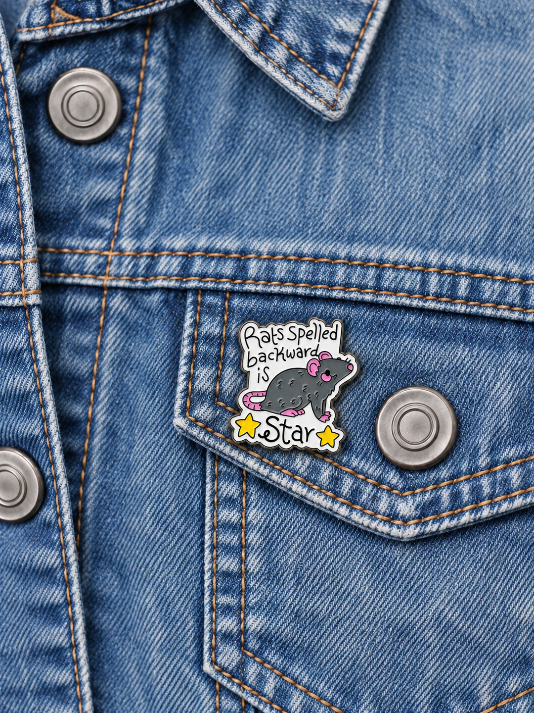 Rats Spelled Backward Is Star Pin displayed on a faded denim jacket beside a metal button