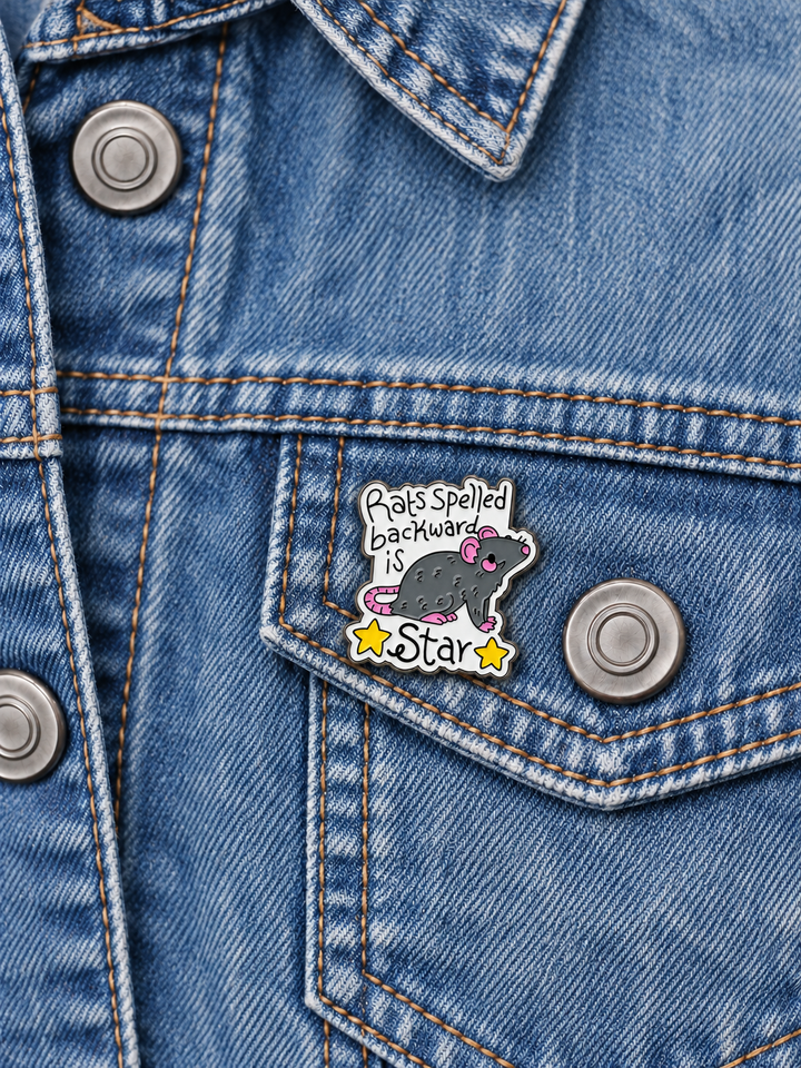 Rats Spelled Backward Is Star Pin displayed on a faded denim jacket beside a metal button