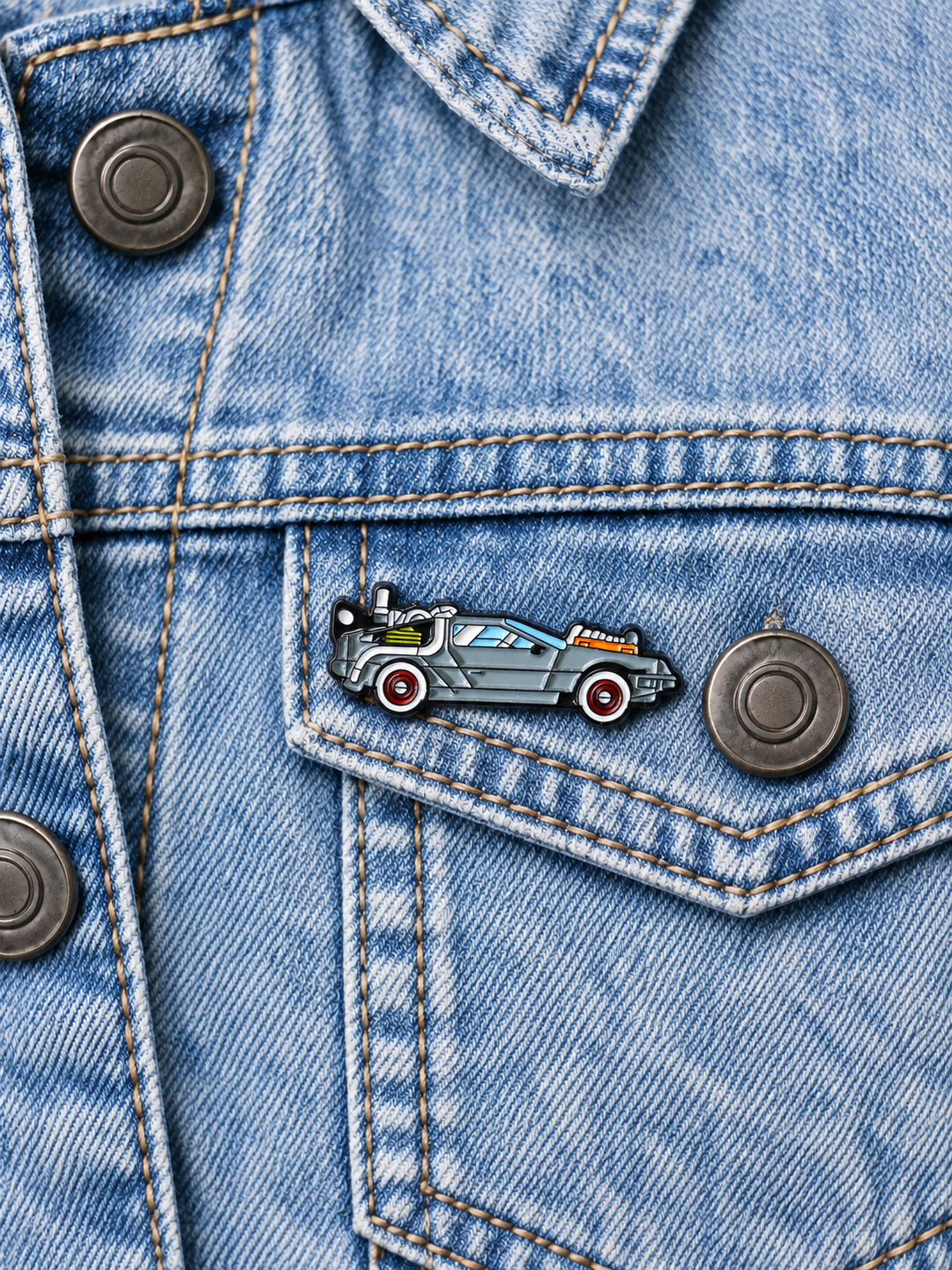 Retro Time Machine Car Pin displayed on a light-wash denim jacket beside a metal button