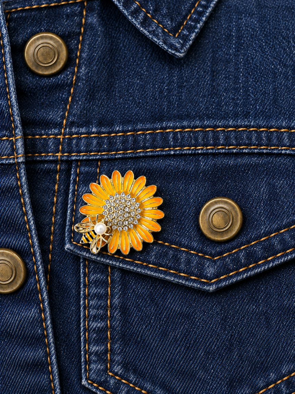 Rhinestone Sunflower Bee Pin displayed on dark indigo denim beside an antiqued brass button